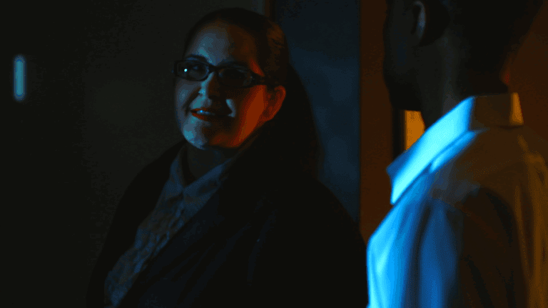 Deep conversation between two professionals in a dimly lit office environment.